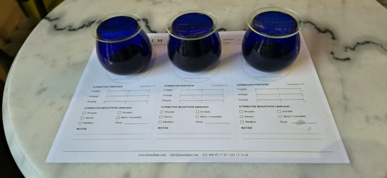 Cata de aceite de oliva virgen extra Lara Olium: copas azules de cata sobre la ficha de cata